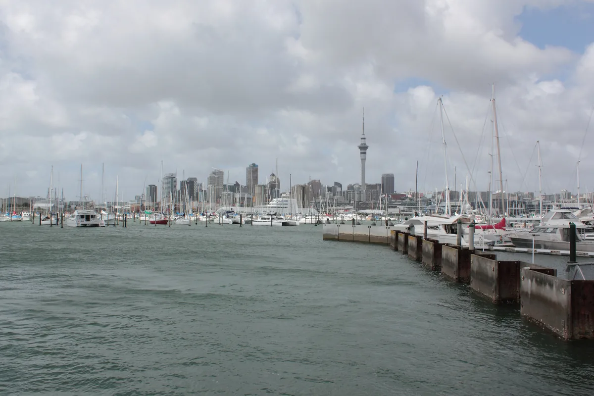 Westhaven Marina, Auckland — launches and motor boats moored with the city skyline and Sky Tower behind